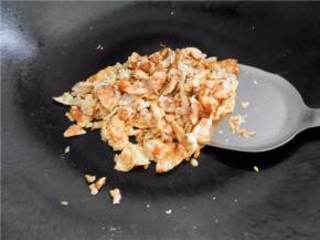 煎熟一面后，将鸡蛋翻面煎熟并炒散。