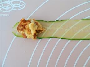 取一青瓜薄片，少量的鸡蛋肉末放在青瓜片的左边头。