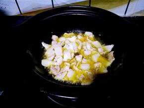 浅煲中倒入适量植物油，烧热之后放入肥瘦相间的猪肉片，翻炒至变色。