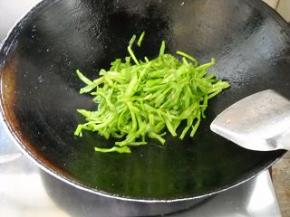 菜梗挤净水分，倒入锅中翻炒。