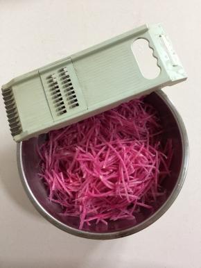 用刨丝器把心里美萝卜刨成细丝备用！