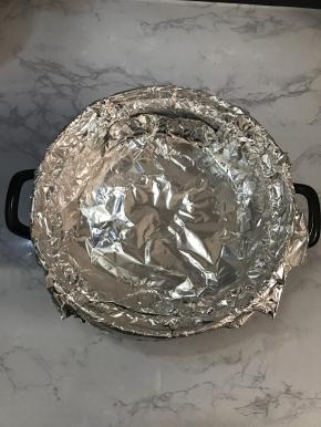 撕两张足够大的锡纸，以十字交叉的方式放在烤架上。贴紧锅壁。多余的锡纸包住砂锅边缘。