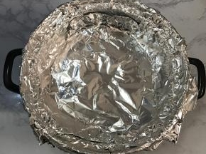 撕两张足够大的锡纸，以十字交叉的方式放在烤架上。贴紧锅壁。多余的锡纸包住砂锅边缘。