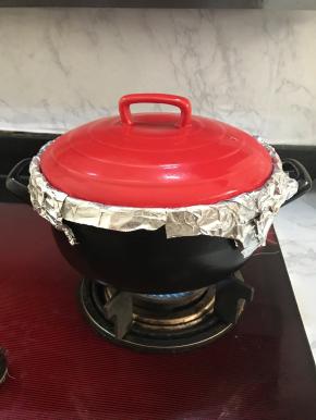 将砂锅放上煤气炉，大火加热20分钟。20分钟后掀起锅盖，用食物夹把红薯翻面。盖上锅盖继续加热20分钟。