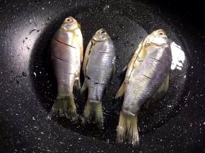 将鲫鱼破肚去内脏洗净后背上划3刀，抹少许盐腌制半小时，锅里放油