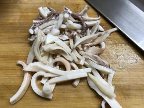 把焯过水的鱿鱼切成细条。