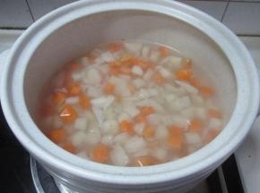 锅里烧开水，把莲藕丁，胡萝卜丁放入汆烫，用砂锅可以防止莲藕氧化。