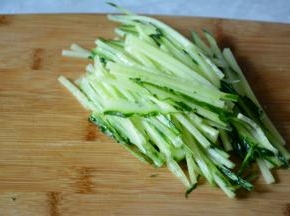 黄瓜洗干净，切丝放入盘中间垫底。