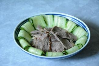 切好的牛肉整齐的摆入盘中，黄瓜薄片摆盘。调好的汤汁淋在牛肉上。