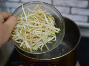将豆芽倒在煮面条的汤中烫几分钟。