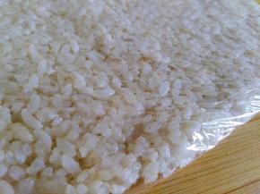 搅拌好的米饭包保鲜膜擀成薄片入冰箱冷冻30分钟左右