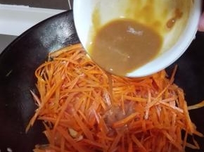 待胡萝卜变软，倒入调好的料汁，翻炒均匀