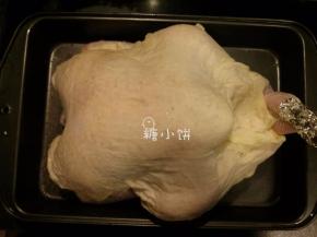 将吸收了黄油的棉布蒙在火鸡表面。送入预热好200摄氏度的烤箱中下层，烤30分钟后取出，在烤盘里倒入200ML清水。再送回烤箱中，转160摄氏度再烤40分钟，每20分钟取出一次将烤盘里的汤汁淋在表面