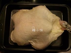 将吸收了黄油的棉布蒙在火鸡表面。送入预热好200摄氏度的烤箱中下层，烤30分钟后取出，在烤盘里倒入200ML清水。再送回烤箱中，转160摄氏度再烤40分钟，每20分钟取出一次将烤盘里的汤汁淋在表面