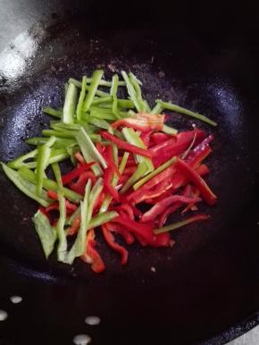 另起锅，放少许的油，放入青红椒丝翻炒片刻