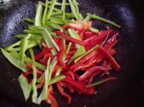 另起锅，放少许的油，放入青红椒丝翻炒片刻