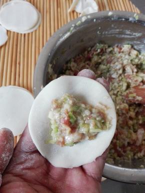 取一个饺子皮，放入适量的馅料