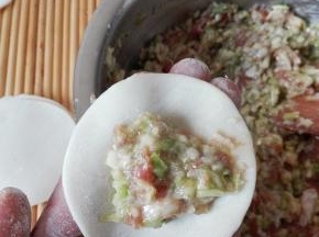 取一个饺子皮，放入适量的馅料