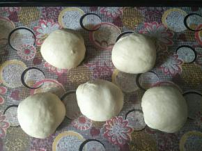 取出发酵好的面团按压排气，均分成五份，滚圆盖住保鲜膜松弛10分钟