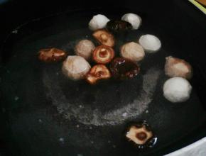 把清水倒入锅中，加入鱼丸，牛肉丸。