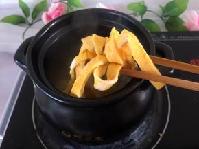 将鸡蛋打散，锅里放少许油，鸡蛋煎蛋皮，切一厘米左右宽条放入煲中