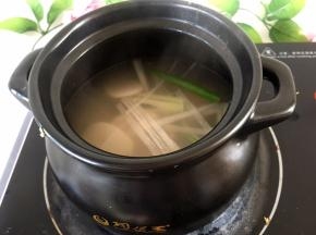 将大葱洗净切段，放入煲中