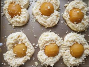 发酵至两倍大以后从烤箱取出，面包表面用刷子轻轻的刷一层蛋液，然后撒椰蓉，黄桃罐头用厨房纸吸净水份，轻轻摁进面包中间，注意要摁进去，不要摆放在上边。否则烤好以后会弹出