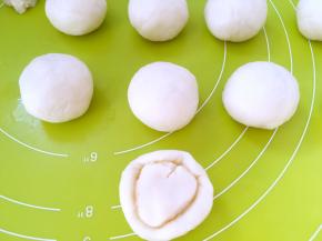 取一份水油皮面团，用手掌压扁，包裹上油酥皮面团，用虎口一点点向上推面团，收好收口，之后松弛10分钟