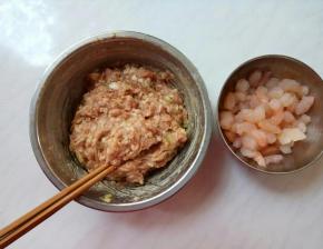 肉馅顺时针方向搅匀，一边搅拌一边分次加入适量清水。
虾仁洗净后用料酒腌制。