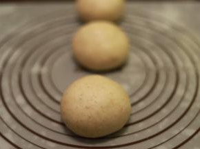 取一小份面团，擀成牛舌状将面团平均分成3份，