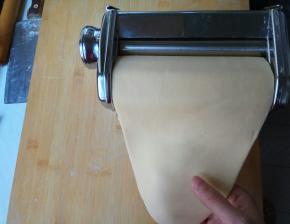 松弛好的面团先擀成一个片，放入压面机中。反复叠加面片碾压，从1档至7档。