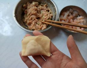 面皮上下对折，捏合。再向两边弯曲，重合捏紧。