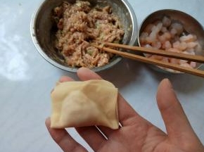 面皮上下对折，捏合。再向两边弯曲，重合捏紧。