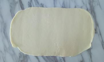 静置好的白糖水面团，用擀面杖擀成面皮