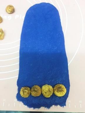 蓝色大面团也擀成长方形 最下面这头放一排无花果干 卷起一圈