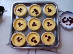 烤箱提前预热5分钟。中层、上下火200℃，放入蛋挞，烤十分钟，取出逐个蛋挞放入几粒蔓越莓。