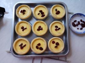 烤箱提前预热5分钟。中层、上下火200℃，放入蛋挞，烤十分钟，取出逐个蛋挞放入几粒蔓越莓。