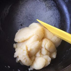 再次开中火，用刮刀大幅度翻拌面糊，仔细检查面糊，确定没有面粉，同时将面糊加热至成团，呈土豆泥状，即可将面糊移至一干净盆中