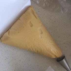 将面糊装入裱花袋中，烤箱210度预热