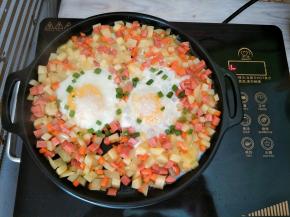 开火两分钟，等烤盘热后关火，利用电陶炉和烤盘的余温将鸡蛋焖熟，鸡蛋撒上适量芝麻和葱花