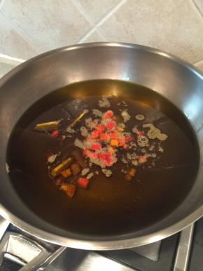 倒入较多的菜籽油加热至7-8成熟，放入姜、八角和切好的红辣椒炸出香味，注意控制火候，油温太高的话辣椒会炸糊