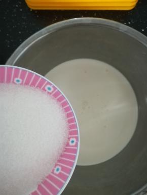 把白砂糖全部倒入奶油里。