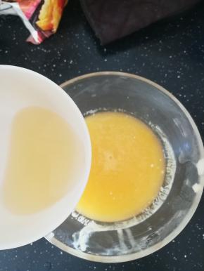 现在做镜面。一片吉利丁隔水融化，倒入黄桃果泥中，搅拌均匀。