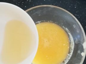 现在做镜面。一片吉利丁隔水融化，倒入黄桃果泥中，搅拌均匀。