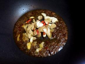 放入泡椒、泡姜、蒜片炒出香味。