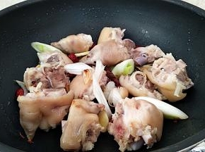 倒入猪蹄煸炒一会，炒掉表面水分。