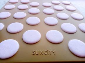 把和好的马卡龙糊装入裱花袋里，均匀的挤在阳晨马卡龙烤盘上。