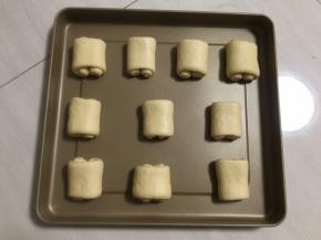 卷紧，每一个面团都如此卷好，卷好的面团放入烤盘，每一个面团之间要留空隙，喷壶喷上清水保湿，放入烤箱，发酵档发酵40分钟