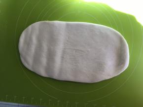 取出发酵好的面团，擀扁排出气体