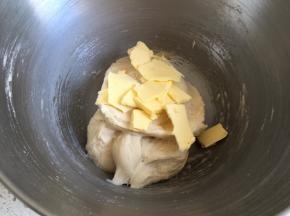 搅拌到面团不粘手，放入软化的黄油，继续揉面